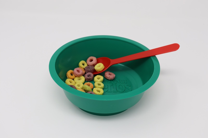 Green plastic bowl with cereal and Harco's #97 spoon in red.