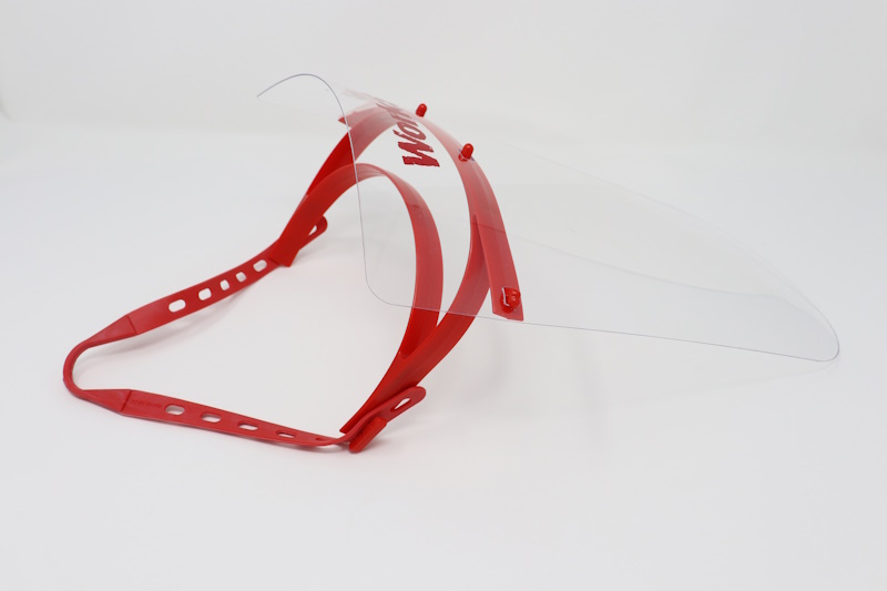 Face shield with a red plastic head band and a red rubber strap.