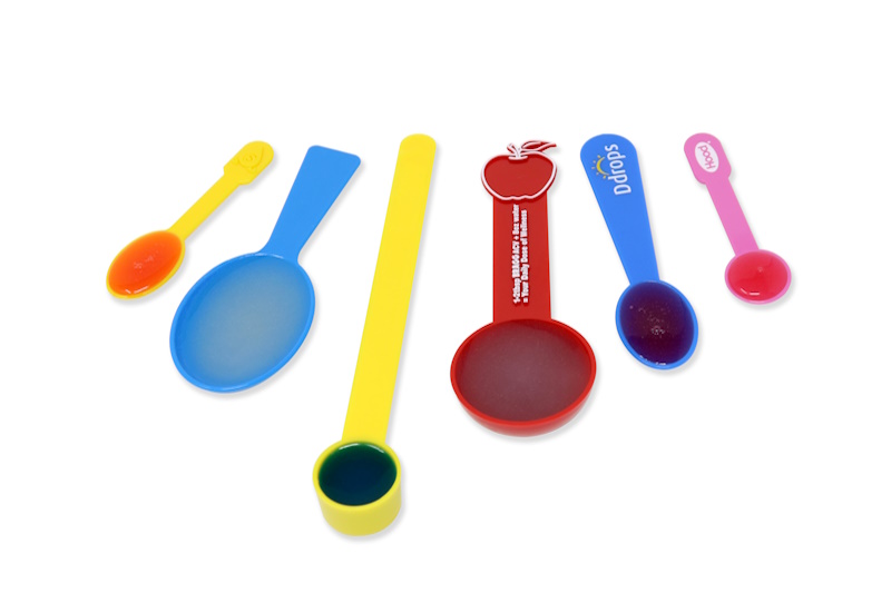 Plastic measuring spoons and scoops with medicine.